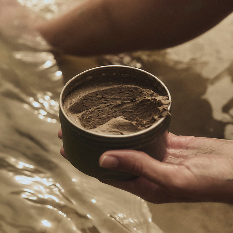 Woman holding jar of mud